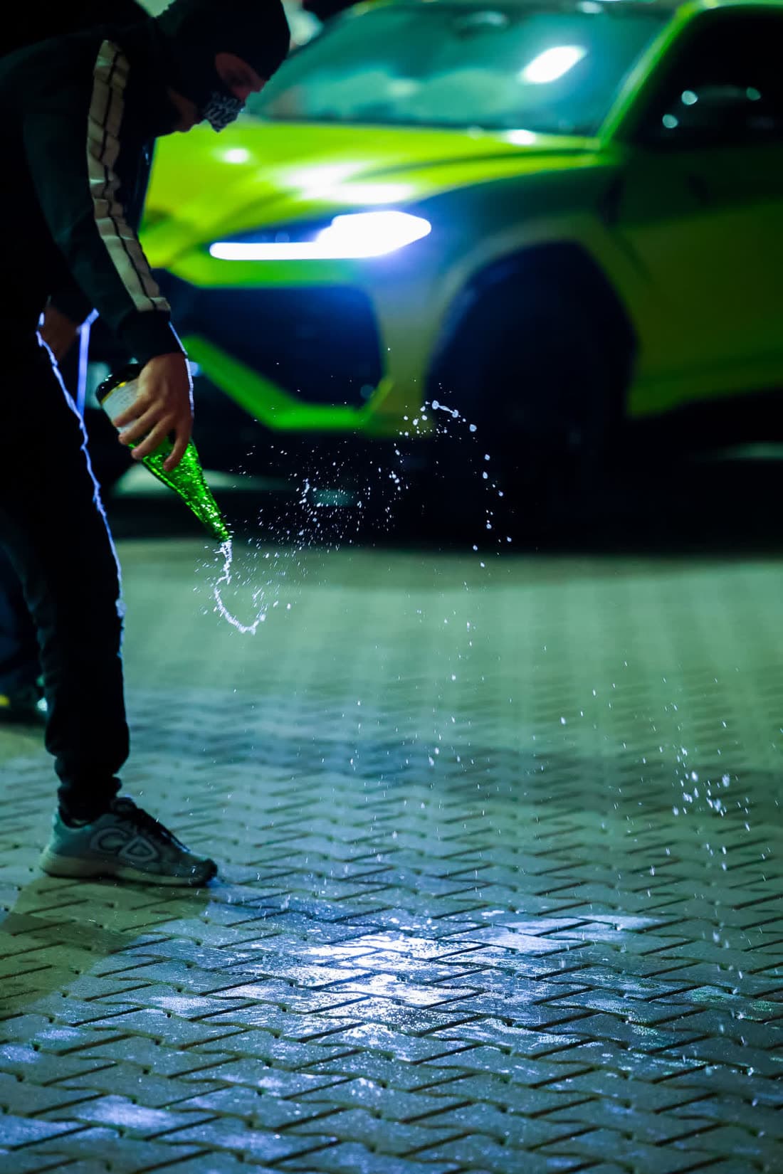 Zielone Lamborghini Urus nocą w świetle reflektorów