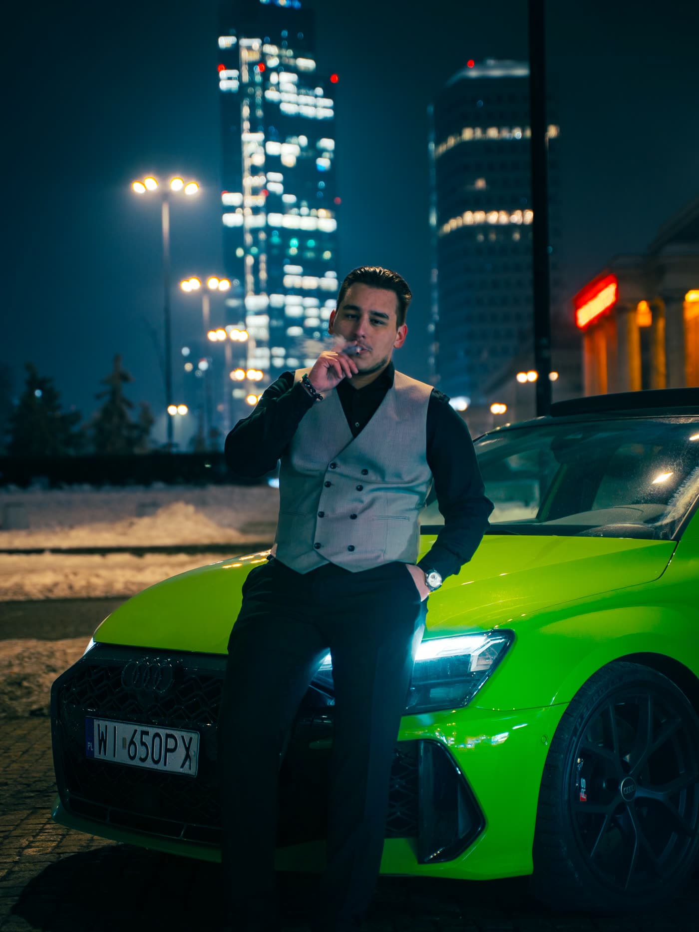Zielone Audi RS3 nocą na tle wieżowców Warszawy